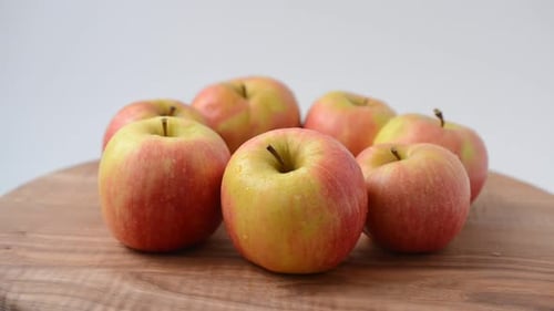 Fresh Apples Rotating on Wooden Cutting Board