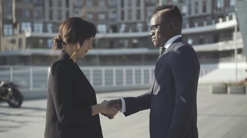 Side View of Multiracial Partners Shaking Hands on Sunny City Street. Handshake of Confident