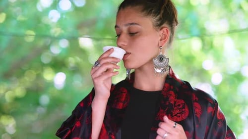 Toma a cámara lenta de una mujer bebiendo de un tazón de té