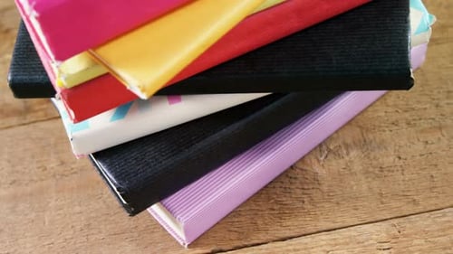 Pile of colorful books on wooden table