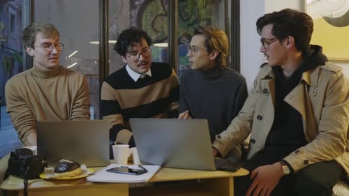 Businessmen Having Discussion in Cafe. Colleagues Looking on Laptop Screen