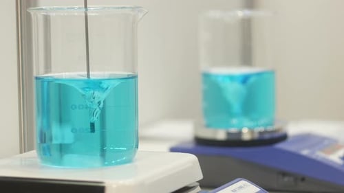 Blue Liquid Being Stirred in Laboratory Beaker