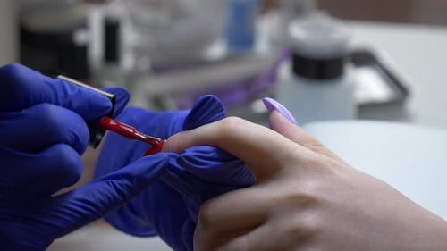 Applying Red Nail Polish in a Beauty Salon