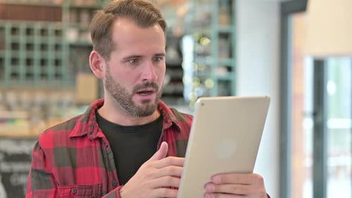 Man Looks Confused While Using Tablet