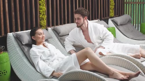 Young Attractive Family Resting on the Sun Loungers in the Spa
