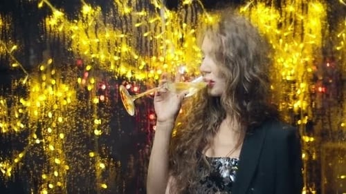 Glamorous Woman Drinks Champagne in Front of Lights