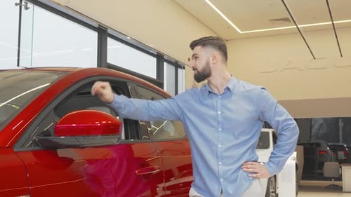 Young Man Inspecting Car at Modern Dealership