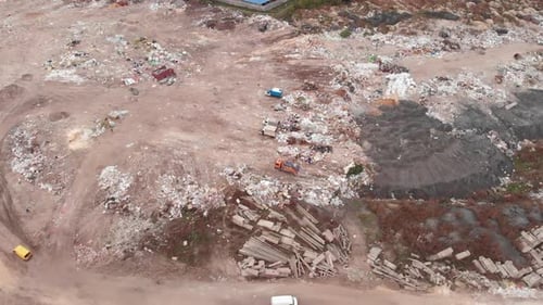 Garbage dump. Bulldozer is pushing debris on field. Construction waste