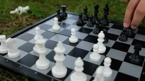 Child Moving Chess Pieces on Board
