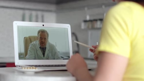 Woman Using Telemedicine App With Doctor on Laptop