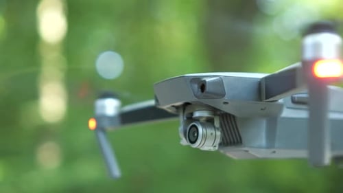 Helicóptero Drone com hélices desfocadas e câmera de vídeo voando no ar