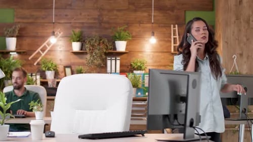 Female Manager Talks on the Phone While Walking in the Office