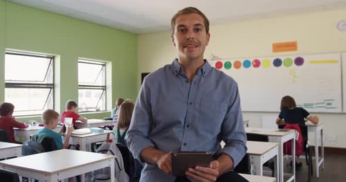 Smiling Teacher With Tablet in Classroom