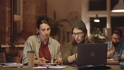 Young Female Coworkers Discussing Job in Office