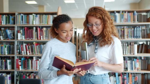 Slow Motion of Smiling Students Beautiful Girls Discussing Book in Library