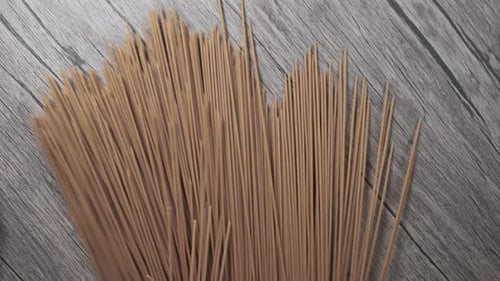 the Spaghetti Crumbles and Falls on the Wood Table. Slow Motion