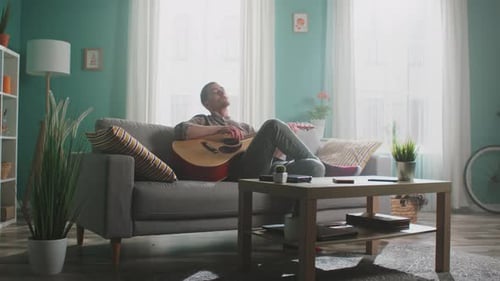 Man Relaxing at Home Playing Guitar