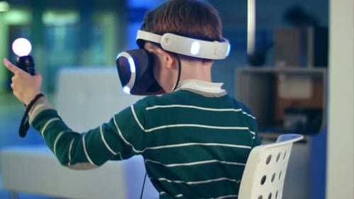 Boy Immersed in Virtual Reality with Headset and Controllers