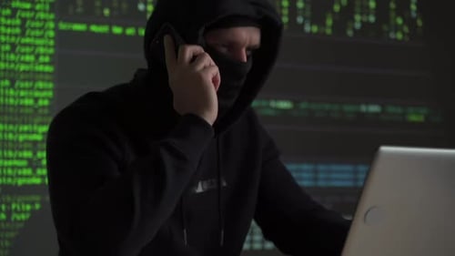 Hacker Talking on Phone with Laptop and Matrix Code