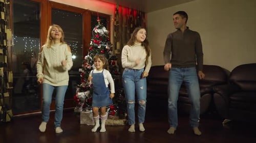 Festive Family Dancing Near Christmas Tree at Home