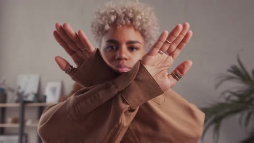 Young African American Woman Demonstrates Stop Gesture Showing Crossed Arms