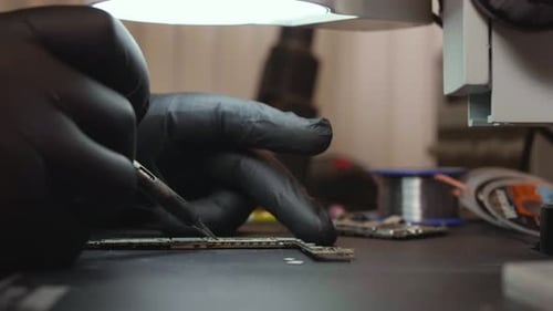 Electronic Component Soldering Repair With Gloved Hands