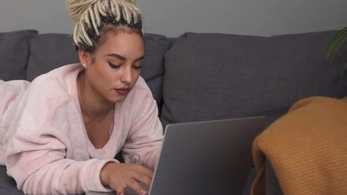 Woman Typing on Laptop While Lying on Couch