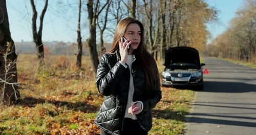 Woman Talking on Phone Near Broken Down Car
