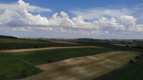 Aerial View of Green Fields and Cloudy Skies