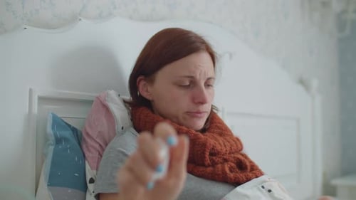 Jeune femme de 30 ans se mouchant le nez avec une serviette et utilisant un inhalateur pour le traitement de maladies comme la grippe ou