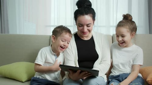 Woman and Children Laughing at Tablet at Home