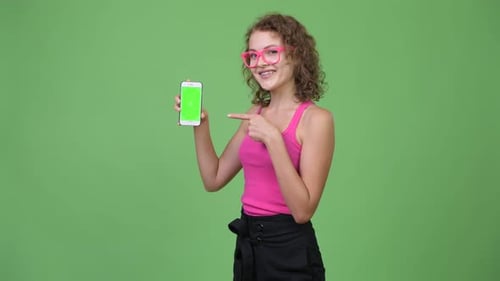 Young Woman Presenting Smartphone with Green Screen