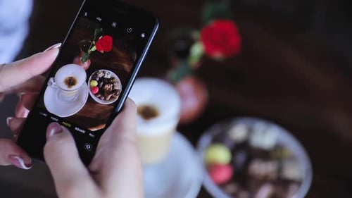 Woman Takes Photo of Coffee and Chocolates