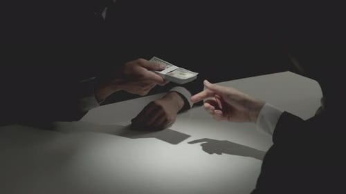 Businessman giving bribe money to his partner and making handshake after negotiation