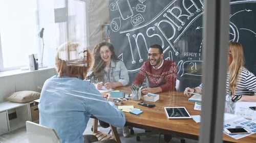 Talented Business Team Smiling and Discussing Ideas at Meeting Table