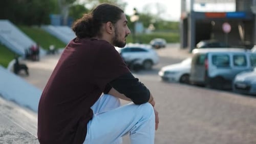 Portrait of Young Attractive Arab Man Sitting on the Stairs in Park at Sunset