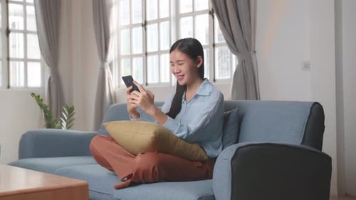 Woman Relaxing at Home with Smartphone