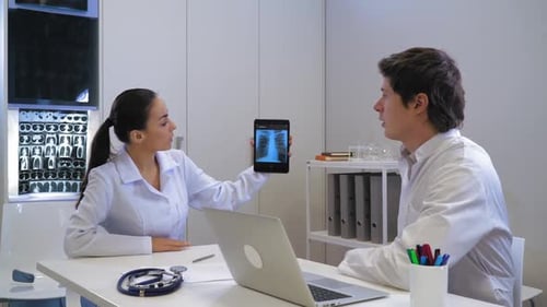 Physician Talking with Assistant in White Office