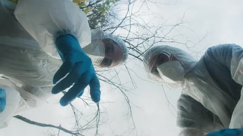 Personas con trajes blancos de Ppe que se muestran con los dedos y discuten