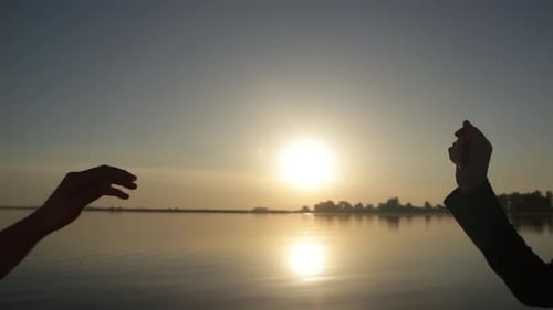 Hands Join at the Lake During Golden Hour