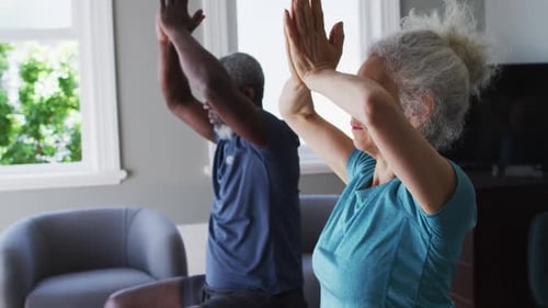Senior Couple Meditating with Yoga Poses Indoors