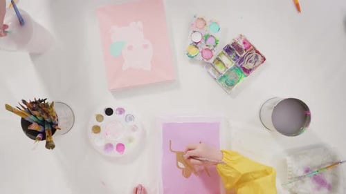 Flat lay. Little girl painting with acrylic paint on canvas with her mother for a distant learning a