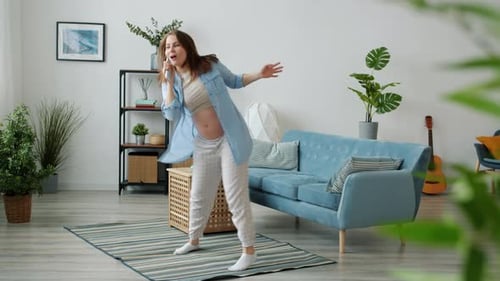 Happy Pregnant Woman Dances and Sings at Home