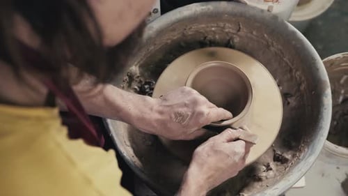 Mains du maître potier et vase d'argile sur le tour du potier en gros plan