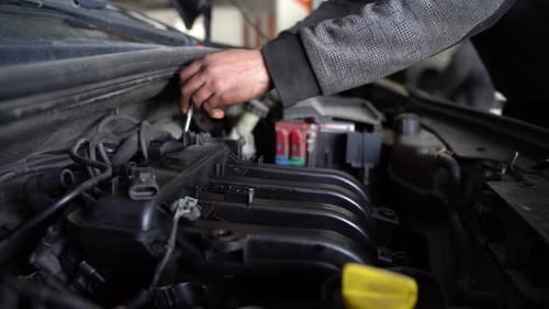 Mechanic Repairing Car Engine with Wrench Indoors