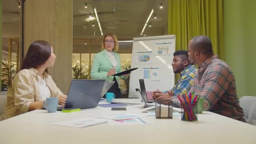 Engaged Colleagues Discussing Charts in Modern Office