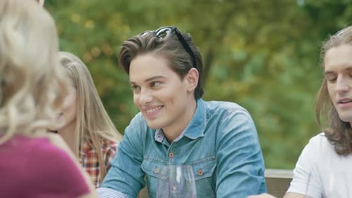 Friends Talking and Laughing Outdoors at Table