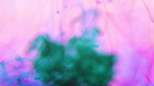 Vibrant Green Ink Swirling in Pink Liquid