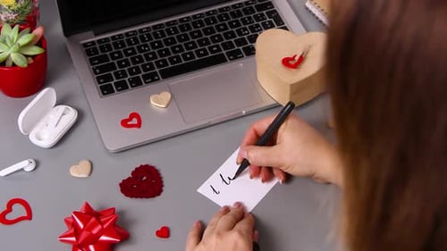 Woman Writing I Love You Note on Card