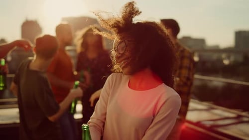 Smiling Friends Socialize at Rooftop Sunset Party